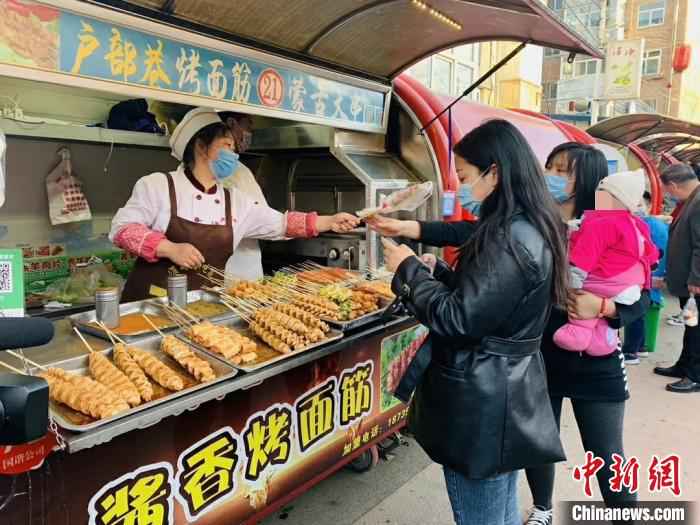 24日,潞州区延南街道淮海小吃街等小吃聚集地已恢复了往日的热闹。 任静 摄 “烟火气”渐浓 山西潞州各行各业复工忙